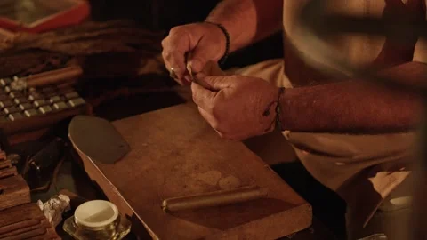 Cigar Maker Crafts a Hand Rolled Cuban Cigar in a Lounge Cutting Tobacco Leaves Stock Footage 288038850