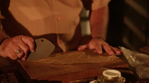 Cigar Maker Crafts a Hand Rolled Cuban Cigar in a Lounge Cutting Tobacco Leaves Stock Footage 288038855