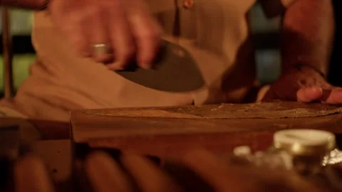 Cigar Maker Crafts a Hand Rolled Cuban Cigar in a Lounge Cutting Tobacco Leaves Stock Footage 288038859