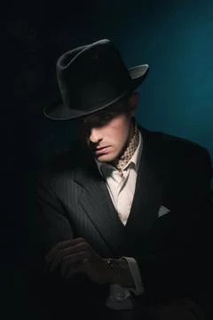Cigar smoking retro gangster with hat in suit. Dark blue background. Stock Photos