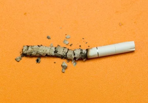 Cigarette ashes on a yellow background Stock Photos