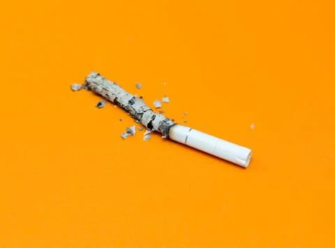 Cigarette ashes on a yellow background Stock Photos