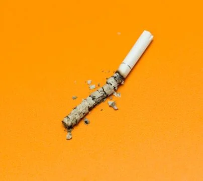 Cigarette ashes on a yellow background Stock Photos