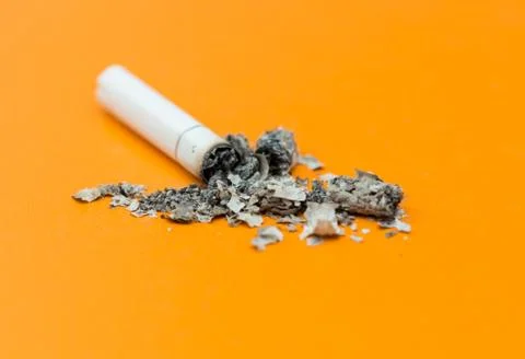 Cigarette ashes on a yellow background Stock Photos