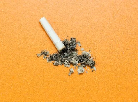 Cigarette ashes on a yellow background Stock Photos