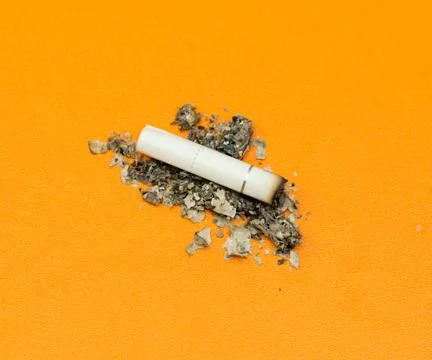 Cigarette ashes on a yellow background Stock Photos