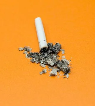 Cigarette ashes on a yellow background Stock Photos