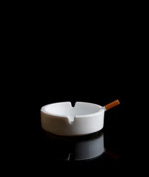 Cigarette in an ashtray on black Stock Photos