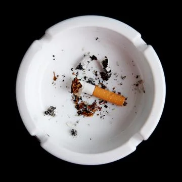 Cigarette in an ashtray on black Stock Photos