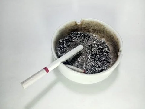 Cigarette in Ashtray with Burnt Ashes Stock Photos