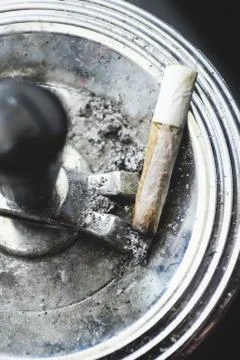 Cigarette on an ashtray on a dark background Stock Photos