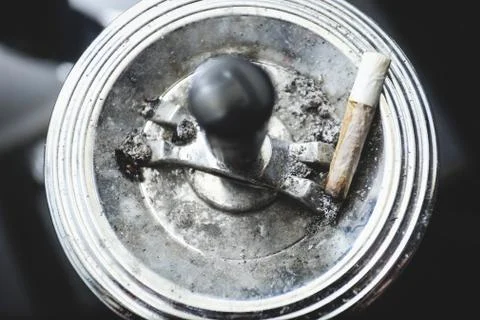 Cigarette on an ashtray on a dark background Stock Photos