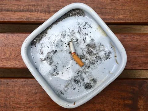 Cigarette on an ashtray dish Stock Photos
