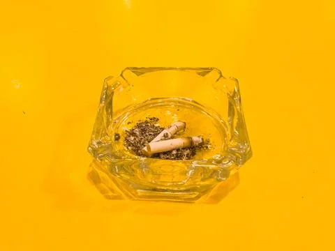 The cigarette ashtray in the middle of the table is yellow Stock Photos