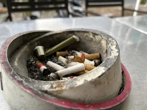 Cigarette in an ashtray on the table. Stock Photos