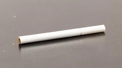 Cigarette on a black table close-up Stock Photos