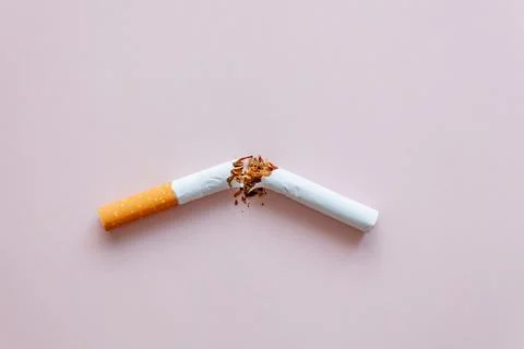 Cigarette is broken on a pink background Foto stock