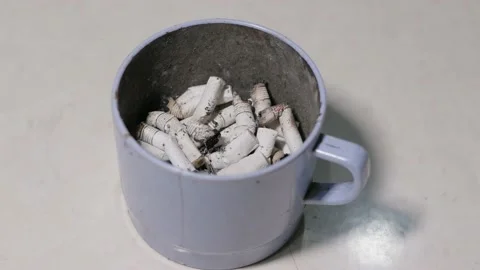 Cigarette buds on a plastic drinking cup Stock Footage 194008795