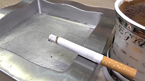 Cigarette Burning on Ashtray, Coffee Mug, Egyptian Mug -  close up, detail Stock Footage 82839299
