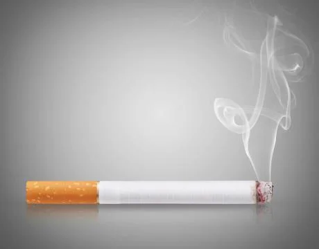 Cigarette burns on gray background Фото