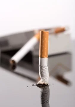Cigarette butt against box Foto stock