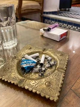 Cigarette butts crashed on a copper ashtray Stock Photos