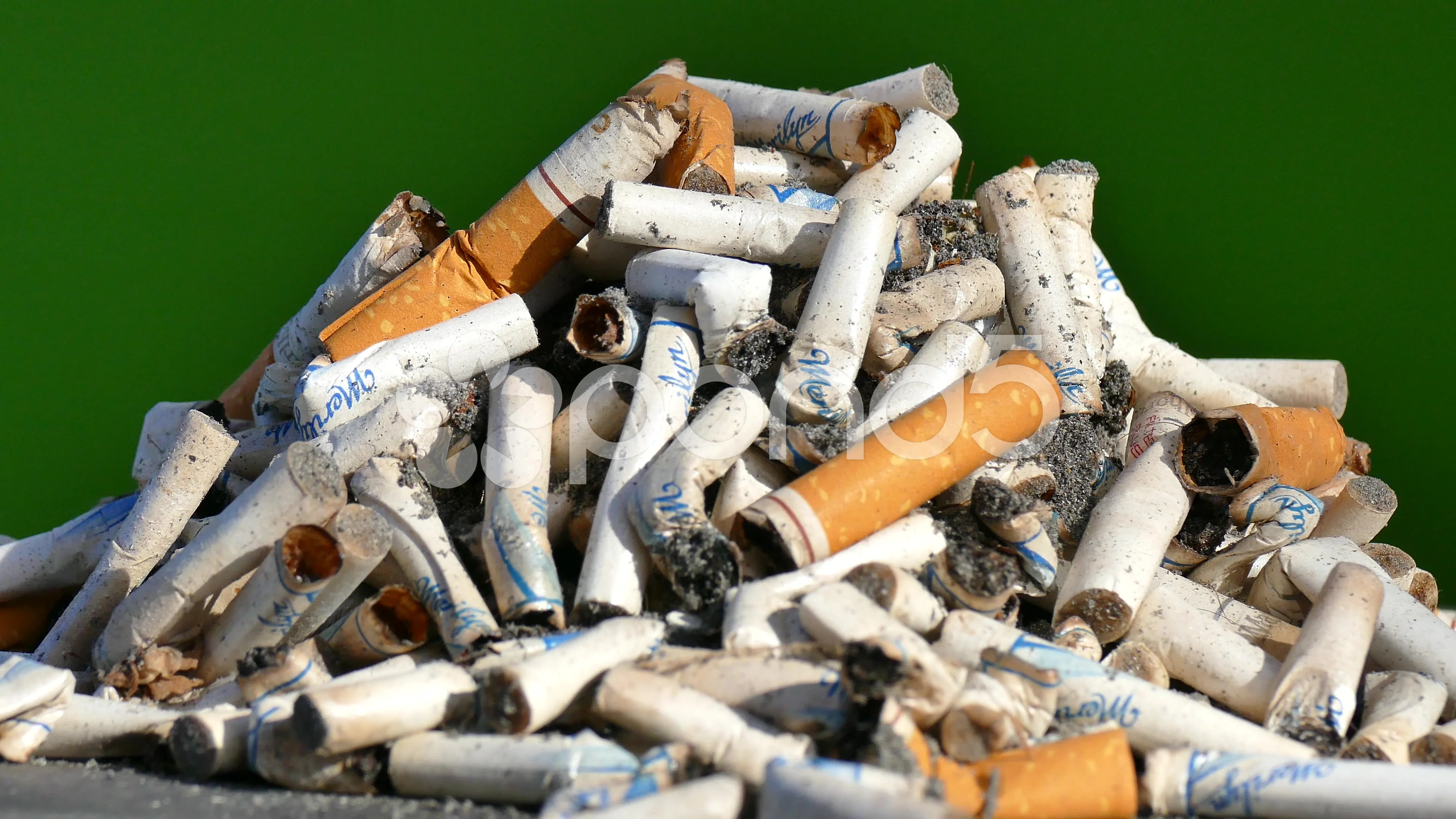 cigarettes with green butts cigarette butts on green background, time lapse, slow motion,