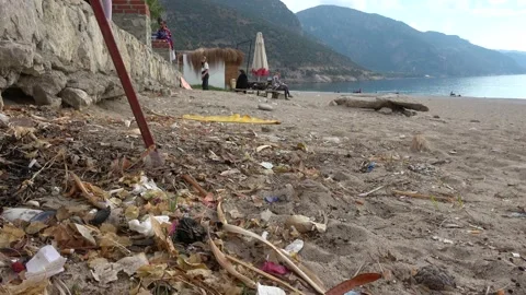 Cigarette ends and other garbage against the beautiful Oludeniz view Stock Footage 143623313