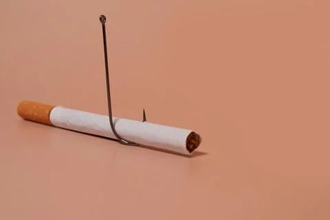 Cigarette with a fish hook on a colored background Stock Photos