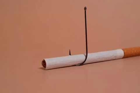 Cigarette with a fish hook on a colored background Foto stock