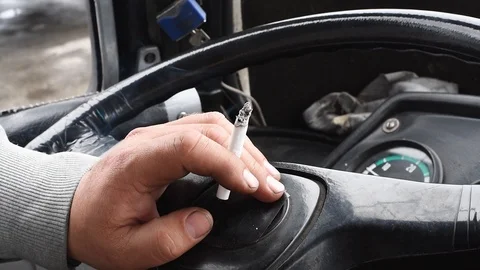 Cigarette in the hand of a man on the steering wheel of a car Stock-Footage 108849774