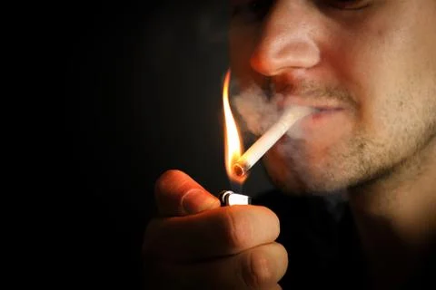 Cigarette ignition on black background Stock Photos