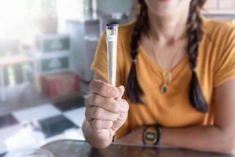 Cigarette joint with marijuana in a package close-up in a woman's hand. Sale of Stock Photos