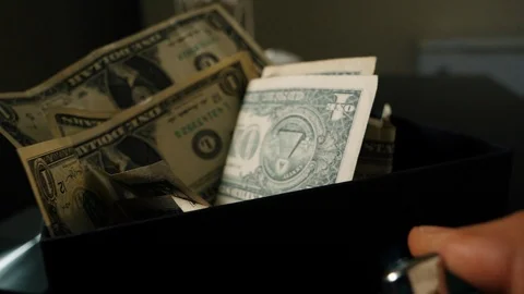 A cigarette lighter emits a flame with dollar bills in a box Stock Footage 109330992