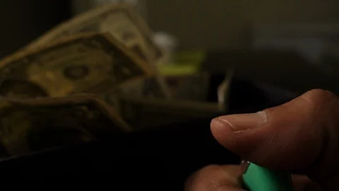 A cigarette lighter emits a flame with dollar bills in a box Stock Footage 109331040