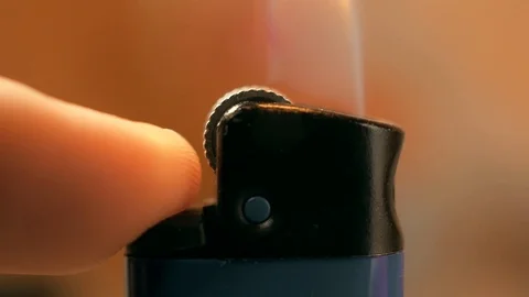 Cigarette lighter ignition in macro with a colored light background Stock Footage 120070039
