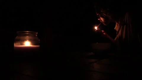 Cigarette lighting in dark next to candle Stock Footage 156258768