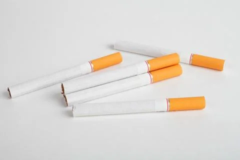 Cigarette with an orange filter on a white background. Foto stock