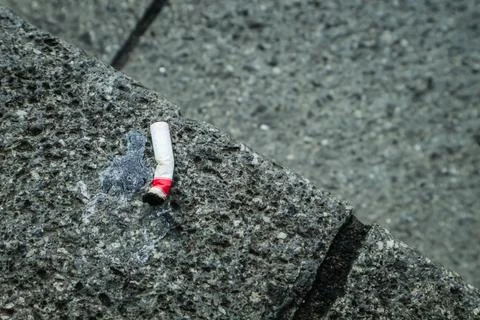Cigarette stubs on the rough floor. Foto stock