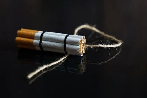 Cigarettes are twisted into a dynamite checker with a filament on a black ref Stock Photos