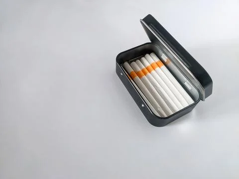 Cigarettes in a black tin box Stock Photos