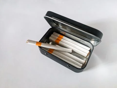 Cigarettes in a black tin box Stock Photos