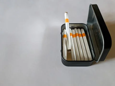 Cigarettes in a black tin box Stock Photos