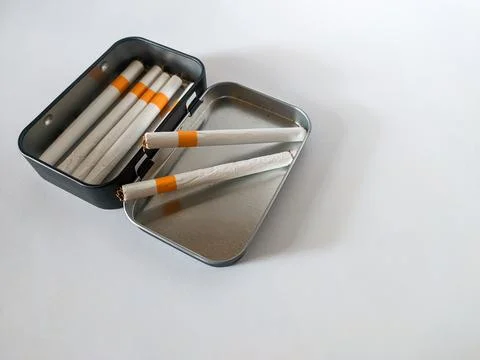 Cigarettes in a black tin box Stock Photos