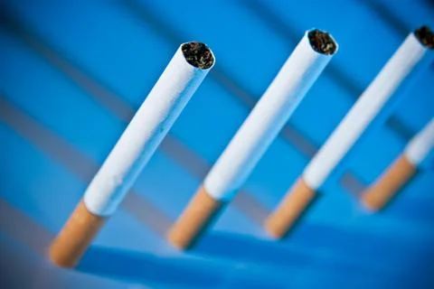 Cigarettes on bright blue background Фото