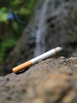Cigarettes in front of the waterfall Stock Photos