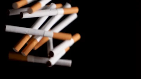 Cigarettes hitting each other and disappear in dark background, studio shot. Video stock 146884262