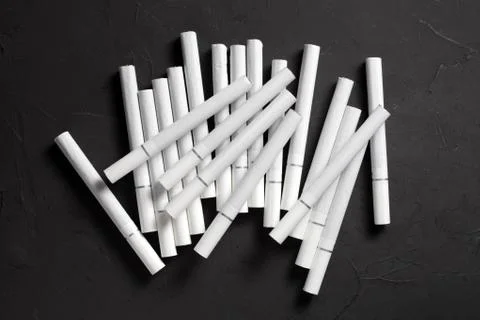 Cigarettes with a white filter on a dark concrete background Stock Photos