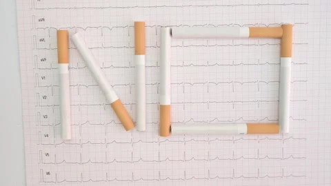 Cigarettes writing the word no on an electrocardiogram Stock Footage 335191990