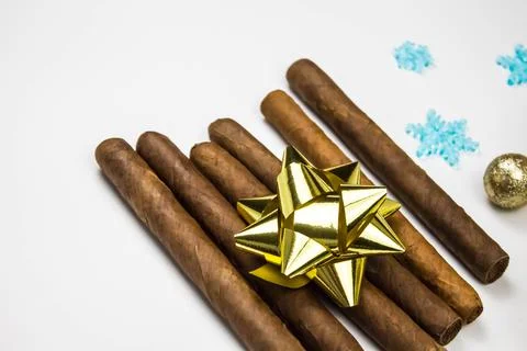 Cigars as a gift on white background. Cigars with gold bow. Stock Photos